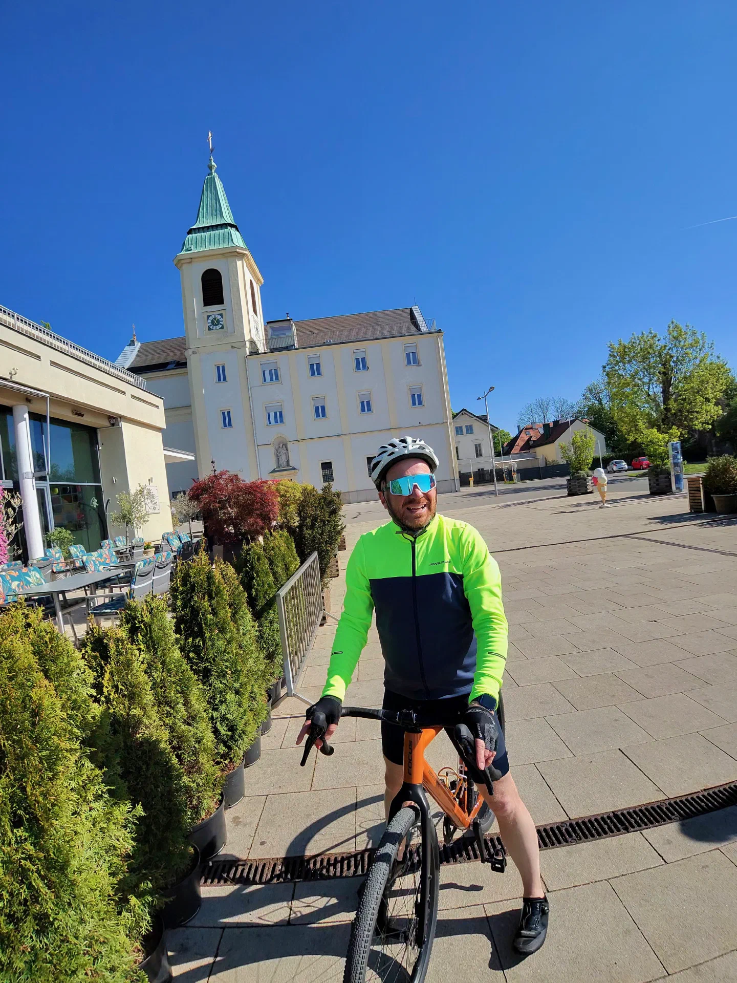 Me on the rented orange gravel bike in front of a Viennese church