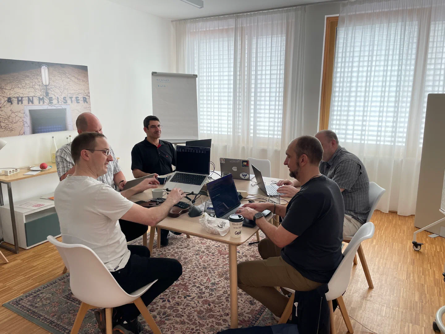 The MetaCPAN team around a table of laptops in a bright meeting room