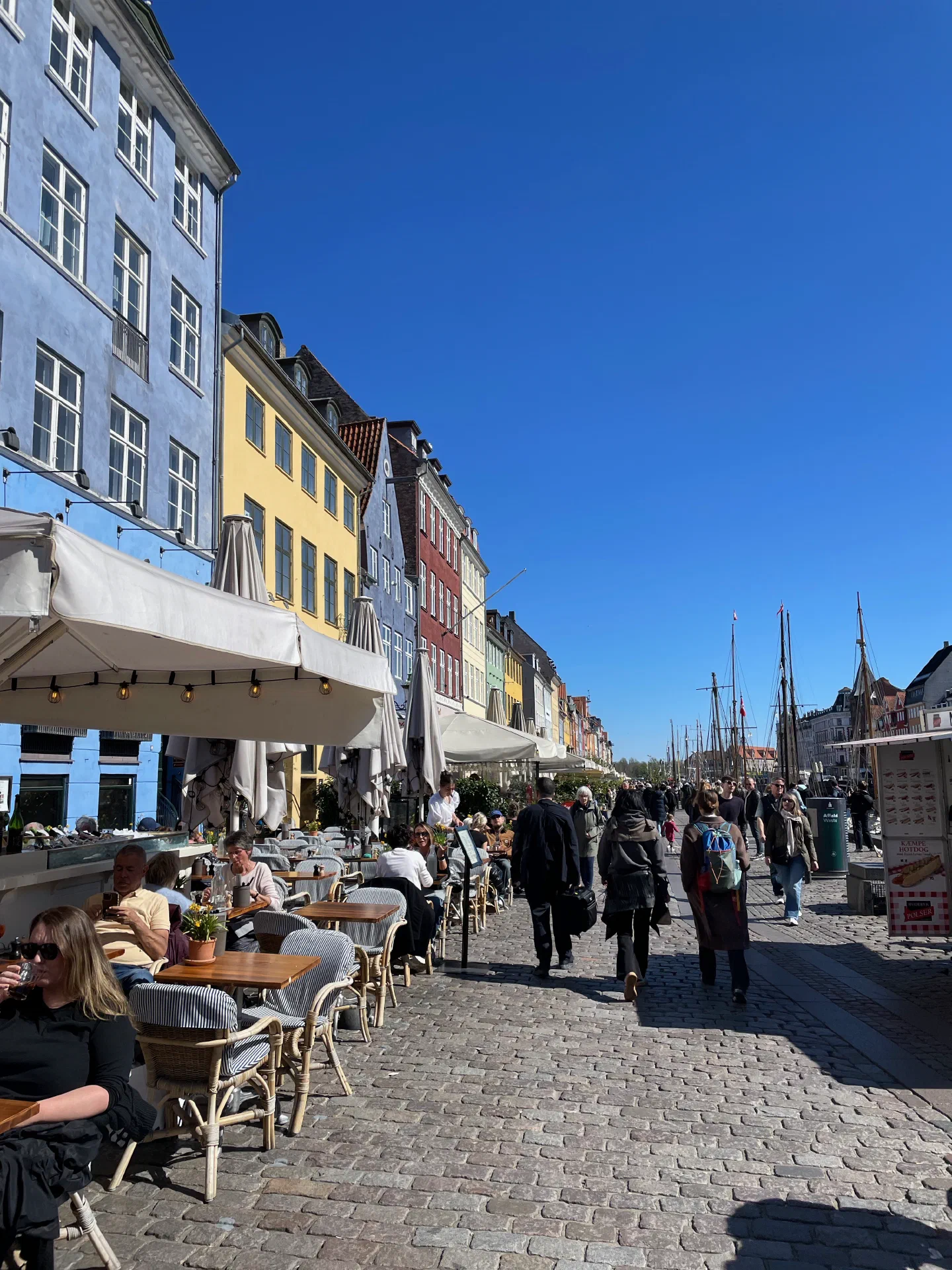 Café tables and sailing boats lining the Nyhavn quay